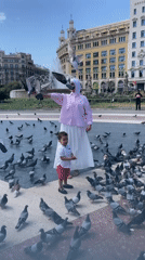 Pigeons gather as locals feed birds in Barcelona square