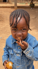 Child photographed eating bread in Nigerian village setting