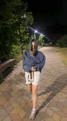 Ginger cat rides along in a hoodie pocket through a Kazan park