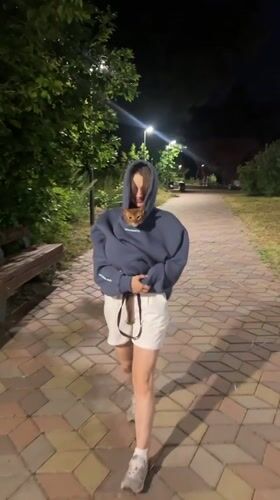 Ginger cat rides along in a hoodie pocket through a Kazan park