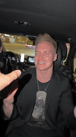 Man lip-syncs to music in car backseat in Moscow