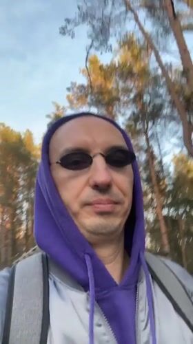 Man in purple hoodie walks through Tallinn streets