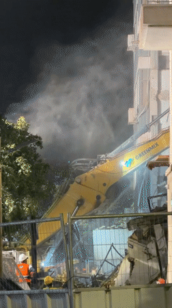Night demolition operation underway in Tel Aviv with excavator