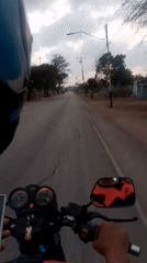 Motorcycle rider travels through Altagracia, Venezuela streets at night