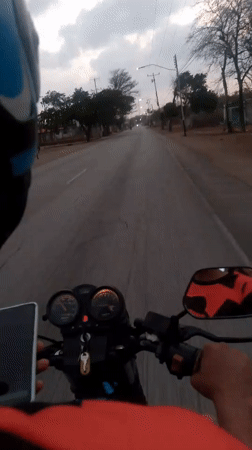 Motorcycle rider travels through Altagracia, Venezuela streets at night