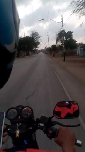 Motorcycle rider travels through Altagracia, Venezuela streets at night
