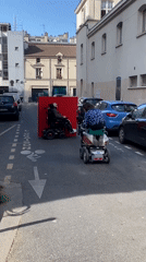 Paris street activity involves mobility scooters, possible filming