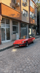 Vintage Alfa Romeo Spider among classic cars on Veliko Tarnovo cobblestones