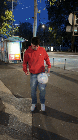 Man juggles soccer ball at bus stop in Rijeka