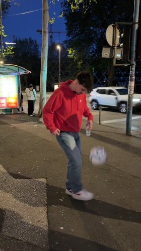 Man juggles soccer ball at bus stop in Rijeka