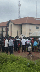 Crowd gathers outside building in Ihiagwa, Nigeria