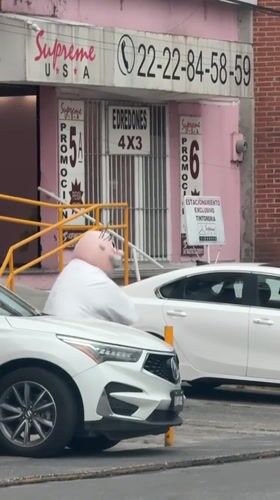 Costumed man with pink head spotted outside Puebla business