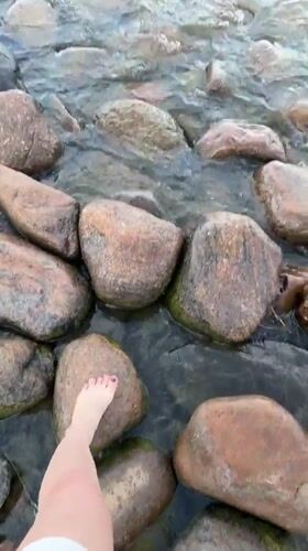 Barefoot at Lake Ladoga, beside a striped lighthouse