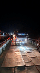 Nighttime traffic crosses temporary bridges in Aceh, Indonesia