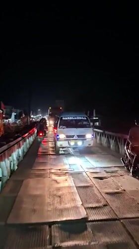 Nighttime traffic crosses temporary bridges in Aceh, Indonesia