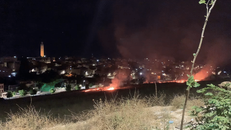 Nighttime grass fire burns along residential edge of Meknes