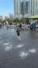 Child plays in water jets at Mississauga fountain
