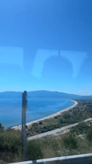Scenic Greek coastline with sandy beach observed from vehicle