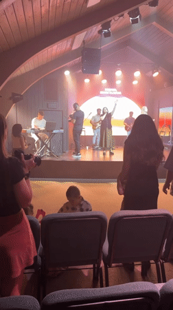 Worship band performs under A-frame ceiling with sunset stage backdrop