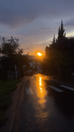 Sunset reflects off wet hillside road in Đà Lạt