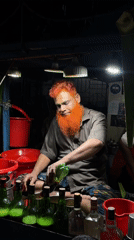 Dhaka street vendor peeling vegetables at a roadside stall