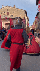 Medieval reenactment parade through San Quirico d'Orcia's historic streets