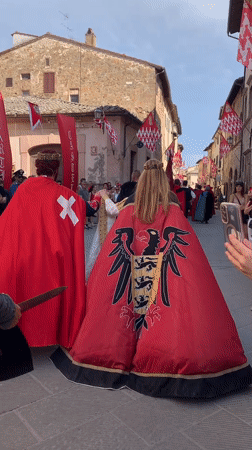 Medieval reenactment parade through San Quirico d'Orcia's historic streets
