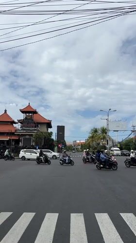 Motorcycle traffic observed at Denpasar intersection early morning