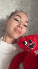 Woman holds distinctive red stuffed toy in Abakan