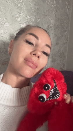 Woman holds distinctive red stuffed toy in Abakan