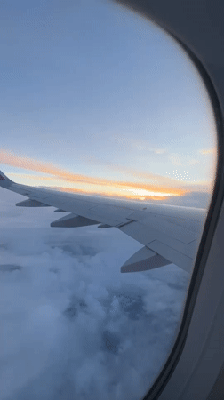 Passenger captures sunset view from airplane wing above Bulgarian clouds