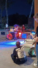 Band performs outdoors in Moscow evening, unrelated cat carrier spotted