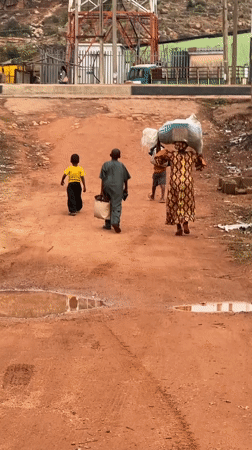 Children walk dirt roads after rain in Gura Top Nigeria