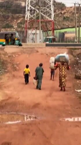 Children walk dirt roads after rain in Gura Top Nigeria