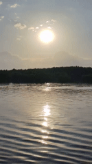 Boat travels on sunlit waters near Novye Shatrishchi, Russia