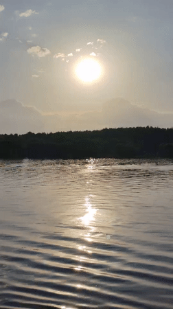 Boat travels on sunlit waters near Novye Shatrishchi, Russia