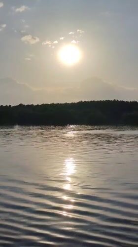 Boat travels on sunlit waters near Novye Shatrishchi, Russia