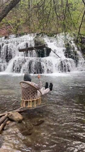 Visitors document scenic waterfall and forest in Bulgarian countryside