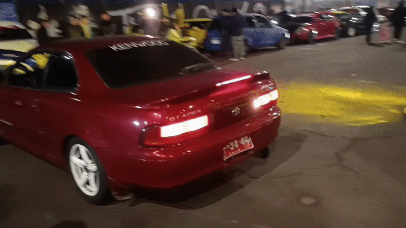 Car meet and street dancing around Arica sign