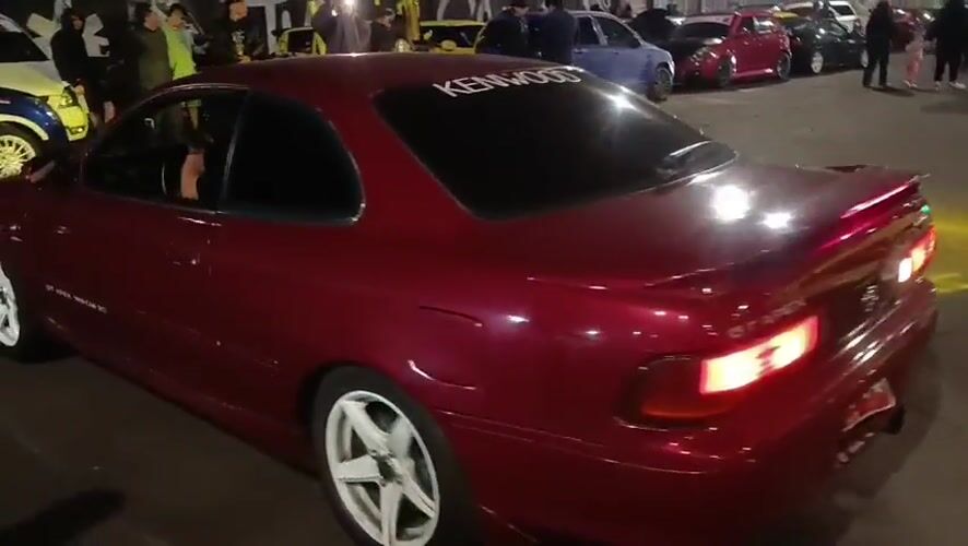 Car meet and street dancing around Arica sign