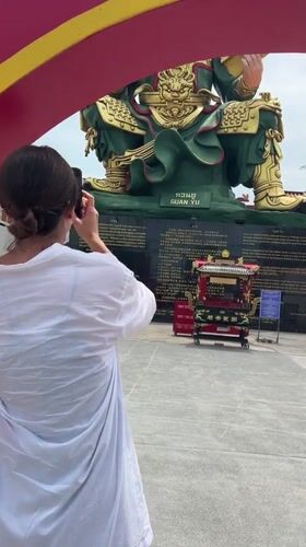 Woman photographs Guan Yu statue in Thailand