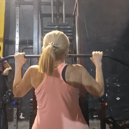 Woman performs lat pulldowns at gym in Wilde, Argentina