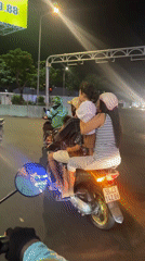 Family of four rides motorcycle together at Vietnam intersection