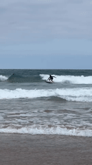 Surfing and shoreline scenes at La Concha on a cloudy morning