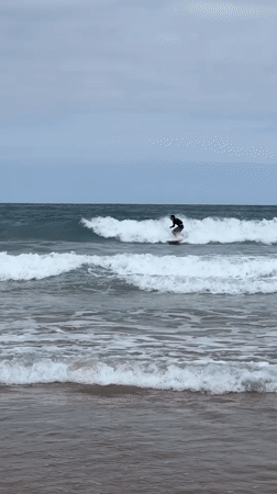 Surfing and shoreline scenes at La Concha on a cloudy morning