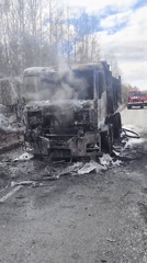 Burnt truck smoking on roadside in Zavod Mikhailovskii, Russia