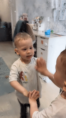 Toddlers engage in household activities in Rusanovo home