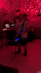 Musical performance with keytar in red-lit Buenos Aires room