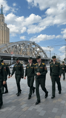 Soldiers walk through busy Moscow street near historic skyscraper