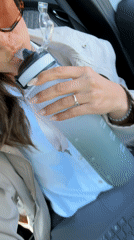Woman works on laptop while hydrating in car, Antibes